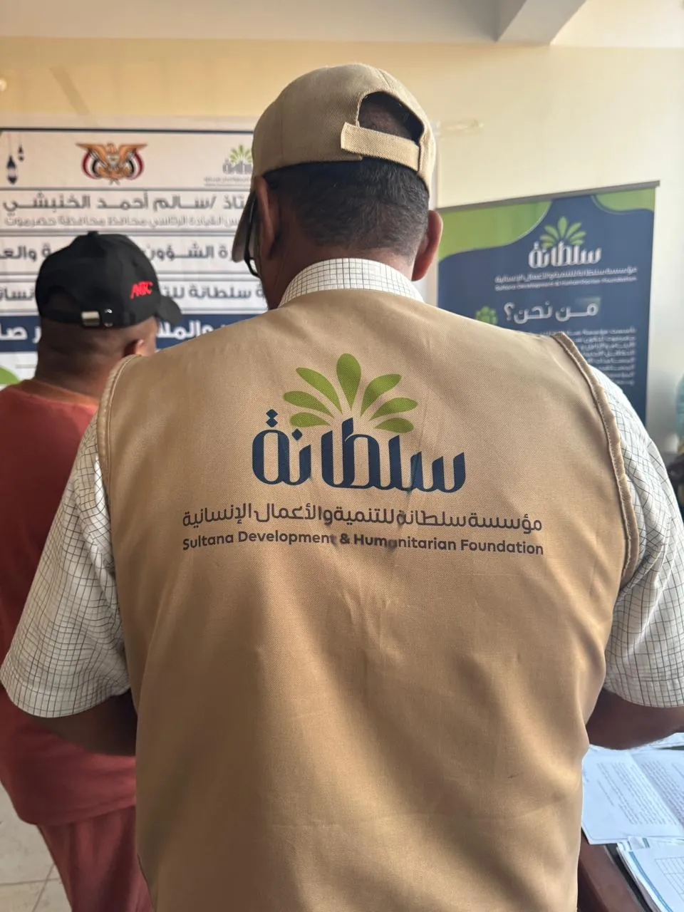 متطوّع يرتدي سترة تحمل شعار مؤسسة سلطانة
