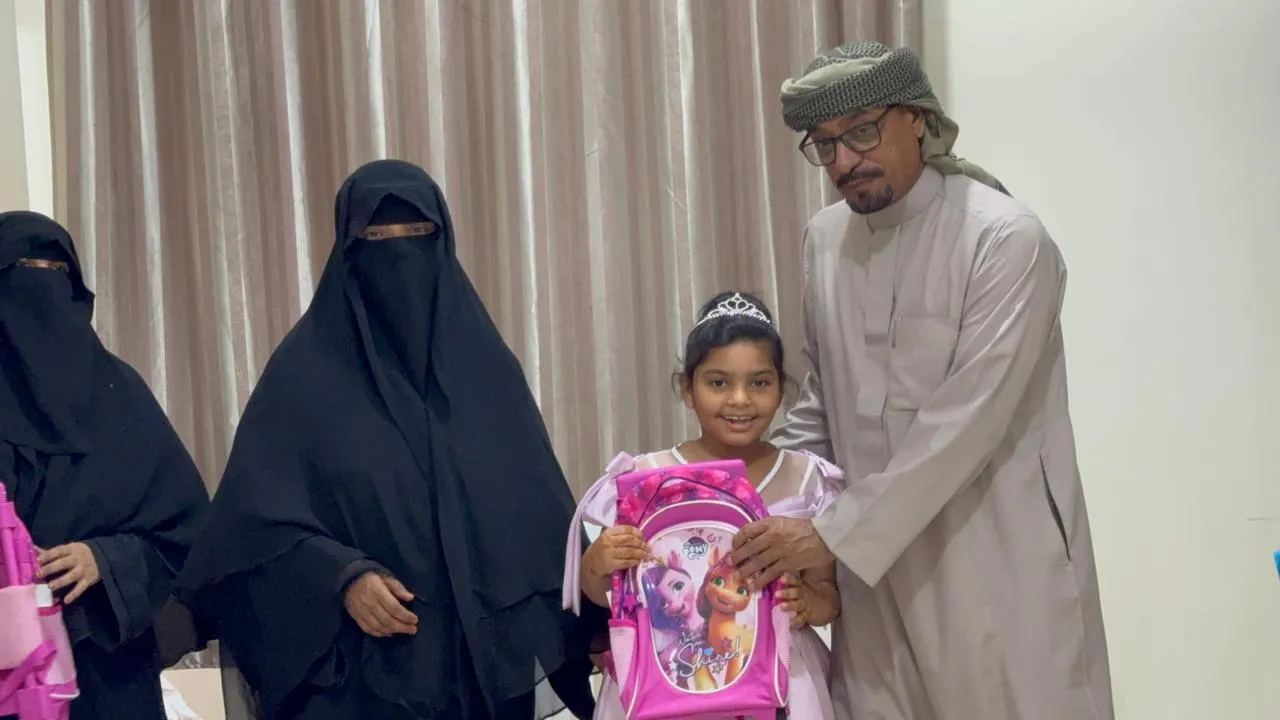 طفلة تستلم حقيبتها المدرسية